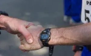 Runner checking watch to see how far did I just run and track pace after finishing a run