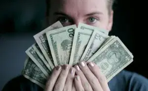 Runner calculating how much is a marathon with cash expenses in hand