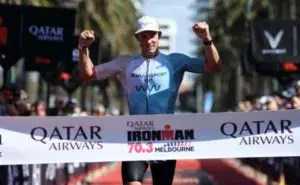 Athlete crossing the finish line at IRONMAN 70.3 Melbourne race in St Kilda