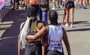 Two runners supporting each other after a race, showing the social perks of running