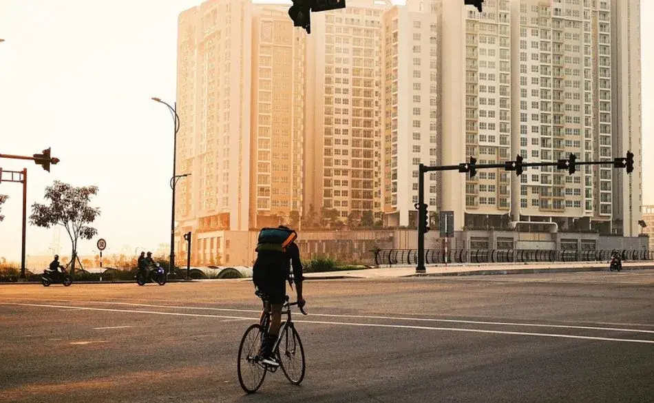 Cyclist riding at sunrise showing the benefits of cycling in the morning