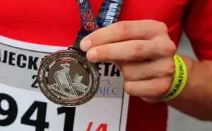 Runner proudly holding a medal after finishing one of the best marathons in Africa.