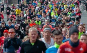 Runners pushing through a crowded city marathon while chasing their Boston Marathon qualifying time