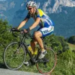 A cyclist riding along a mountain road demonstrating cycling cadence for beginners