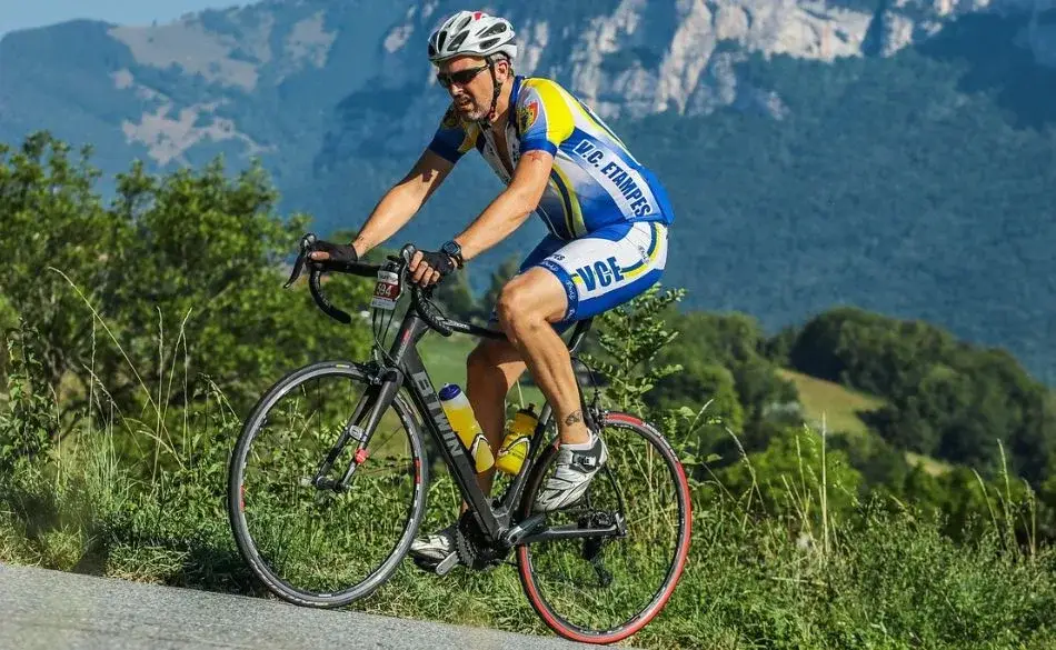 A cyclist riding along a mountain road demonstrating cycling cadence for beginners