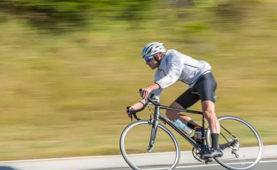 Cyclist demonstrating free speed cycling tips by maintaining aerodynamic position on a road bike