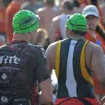 Triathletes preparing at the swim start, showing what it looks like when training for a sprint triathlon and how long it takes to be ready.