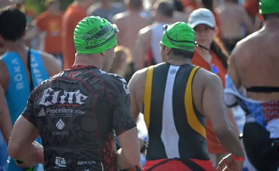 Triathletes preparing at the swim start, showing what it looks like when training for a sprint triathlon and how long it takes to be ready.