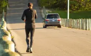 Runner training on a quiet road during a half marathon build while learning how to avoid overtraining