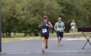 Runner crossing finish line demonstrating how to run faster without increasing your mileage