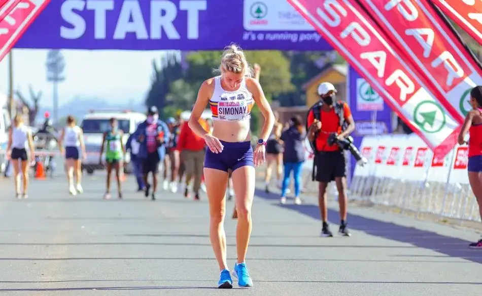 female runner adjusting top before race start to prevent nipple chafing when running