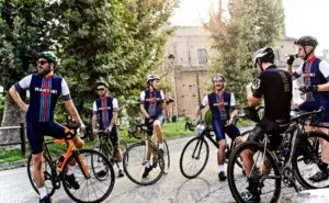 Group of cyclists talking before a ride, reflecting the community aspect of online cycling coaching for beginners