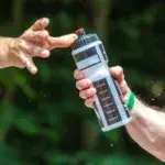 triathlon coach handing a water bottle to an athlete during training