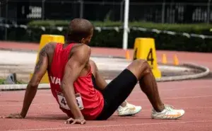 How To Stop Feeling Dizzy After Running athlete sitting on track feeling lightheaded