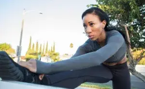 Athlete stretching before training showing focus and early overtraining symptoms