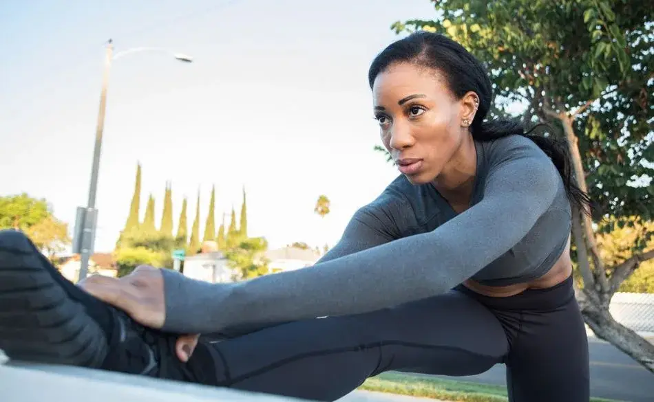 Athlete stretching before training showing focus and early overtraining symptoms