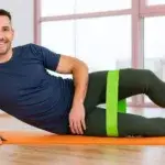 Psoas workout exercise with a resistance band performed by a man on a mat