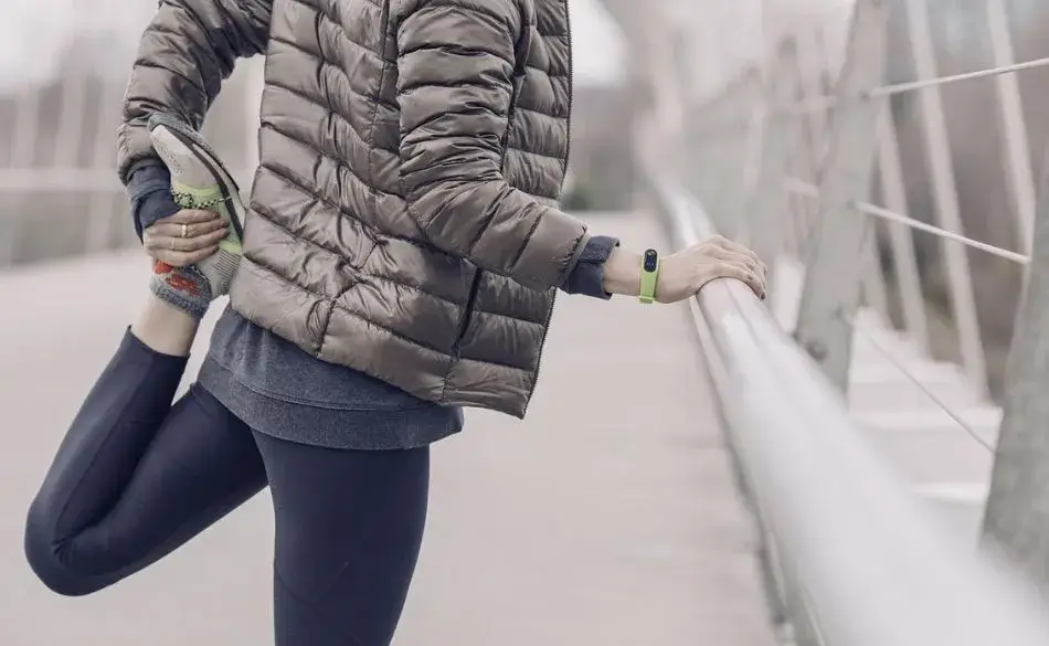 Person doing a quad stretch outdoors, a common movement that can sometimes make people feel sore from stretching.