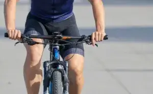 Alt text: Cyclist riding a bike demonstrating glute engagement while pedaling