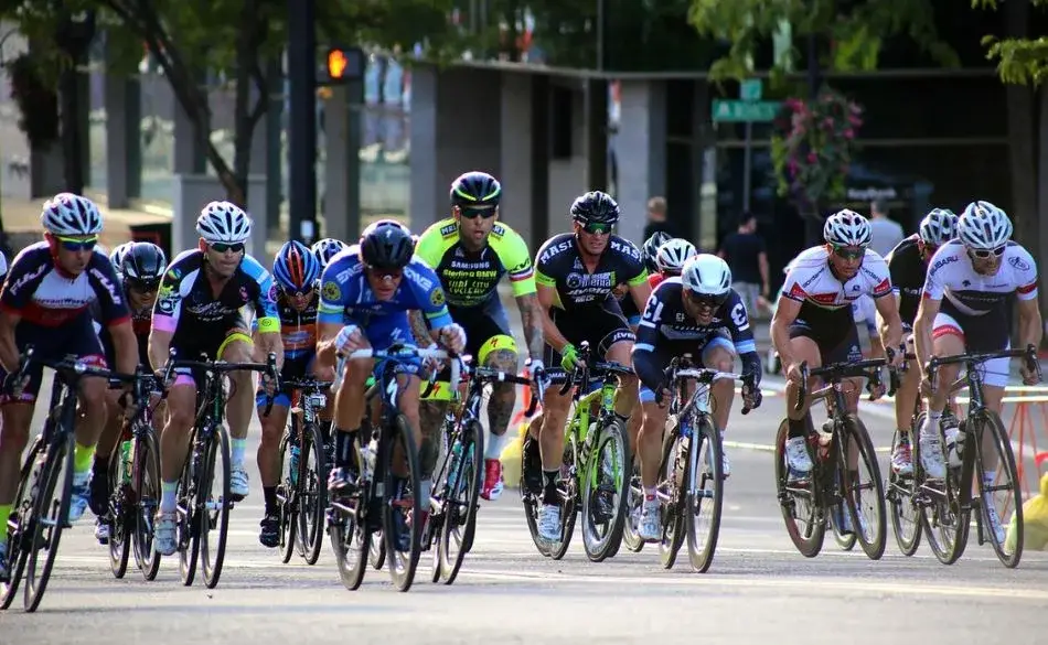 Group of experienced cyclists riding hard in a road race, showing how to maintain FTP as you age