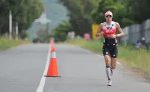 Ironman athlete running during the marathon leg of an Ironman race, demonstrating pacing and endurance under fatigue