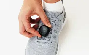 Runner attaching a foot pod sensor to a running shoe to measure cadence
