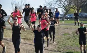 Group of runners celebrating as they run together during an outdoor running event