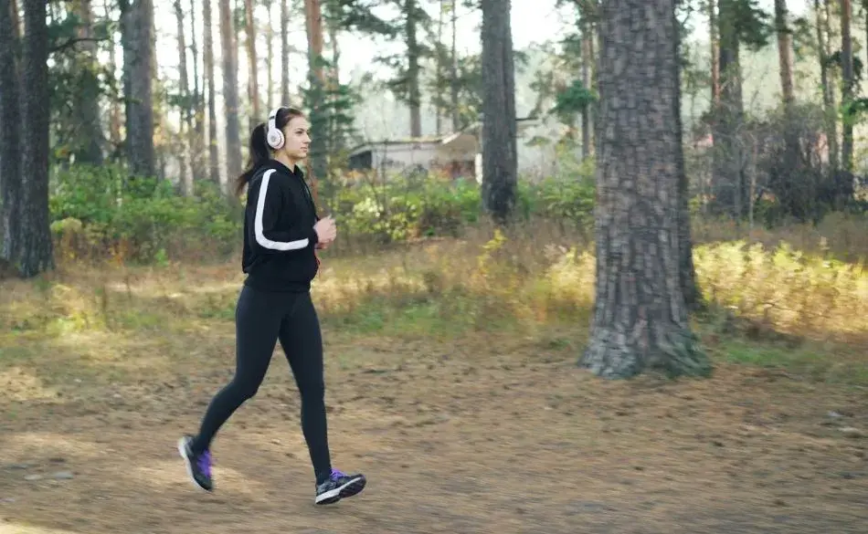 Beginner runner jogging on a park path during an early morning training run