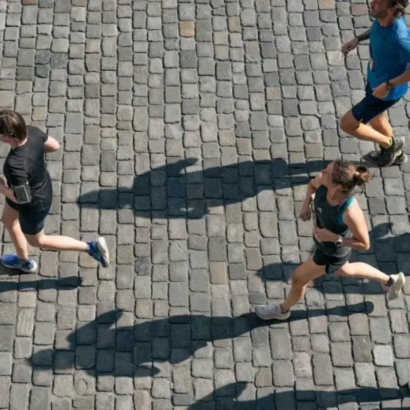 Group of runners participating in a race on a cobblestone road.