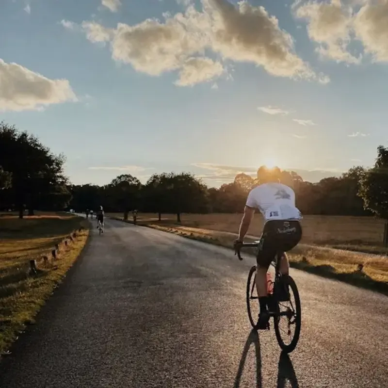 Sydney cycling coach leading a training ride at sunset through a scenic park