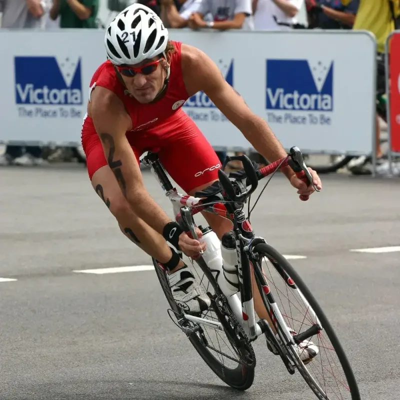 Triathlete cycling during a Melbourne race, taking a corner at speed.